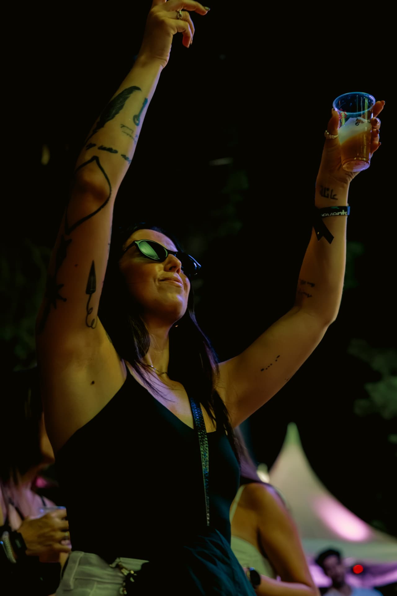 Woman raising her drink to the night