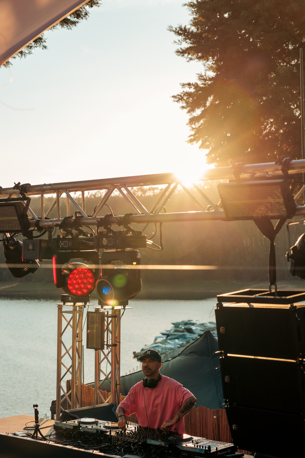 DJ and stage lights silhouetted against the setting sun