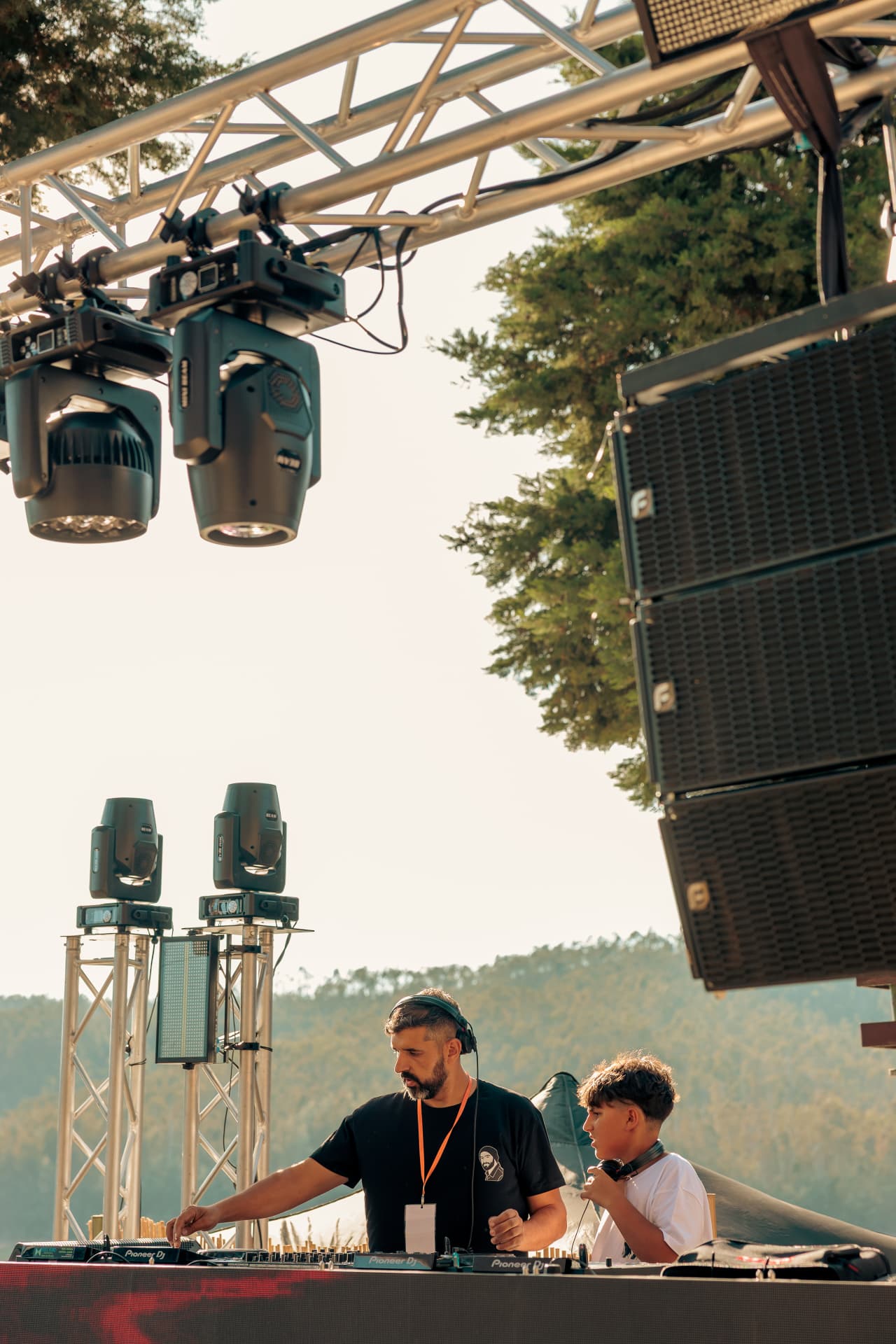 DJs setting up beneath the lighting rig