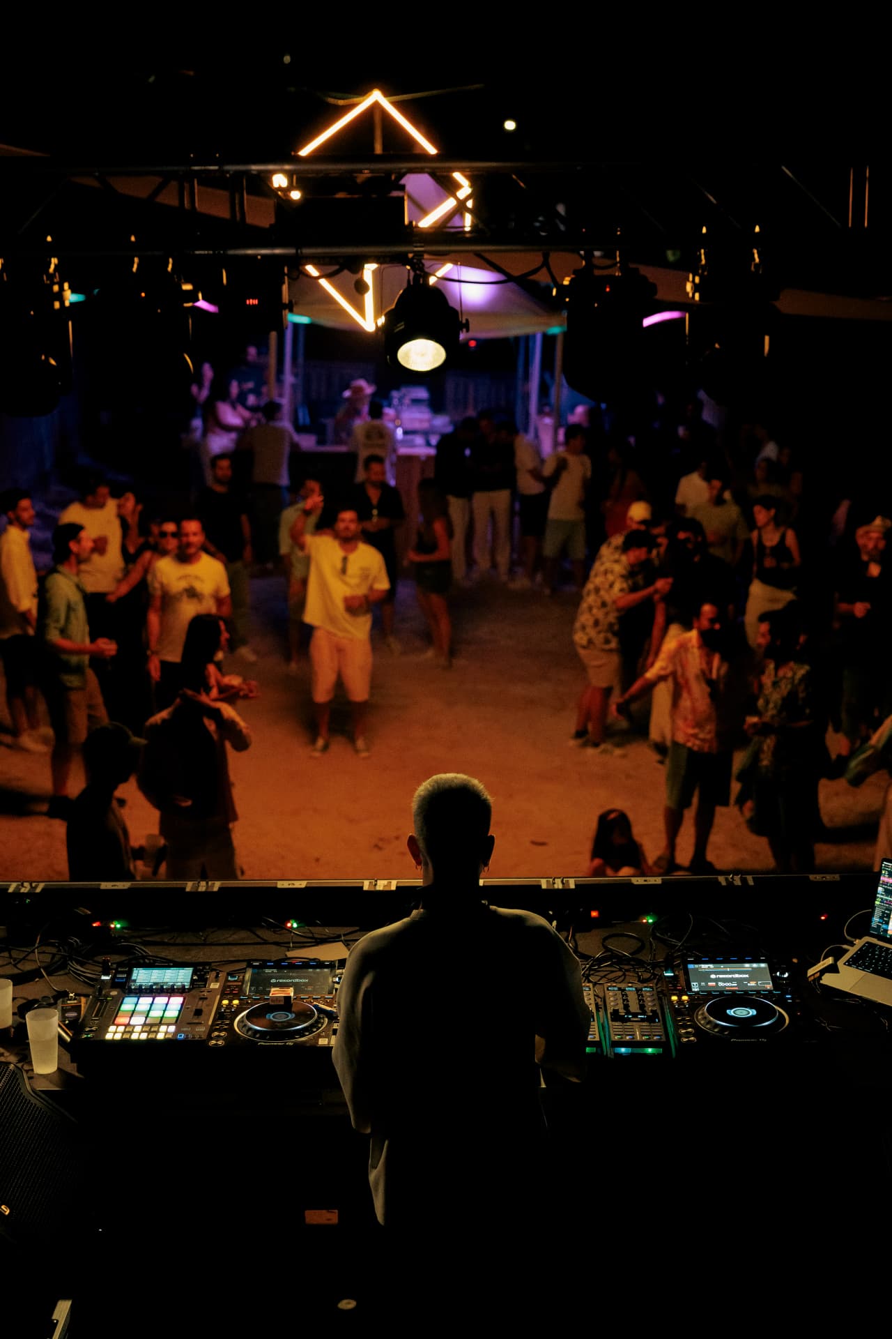 View from behind the booth over the amber-lit crowd
